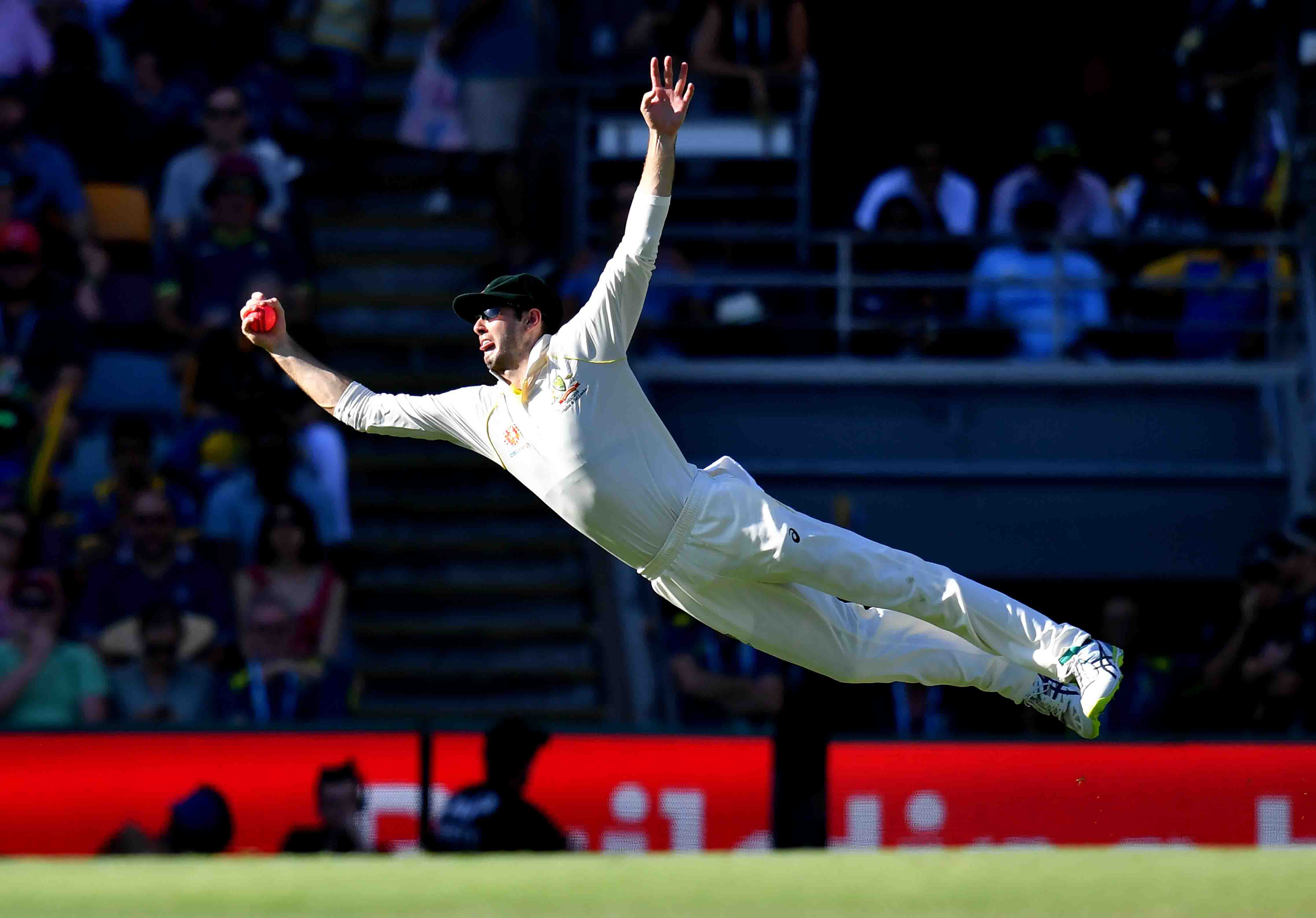 Kurtis Patterson of Australia is seen diving to take a catch to dismiss Dilruwan Perera of Sri Lanka off the bowling of Pat Cummins on Day 3 of the first Test between Australia and Sri Lanka at The Gabba.